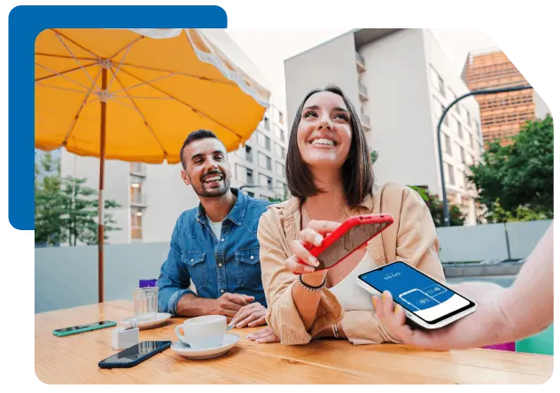 a couple paying at a coffee shop via mobile with the cashier also using a mobile