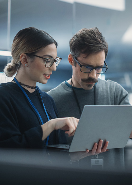 two colleagues reviewing information together on a laptop